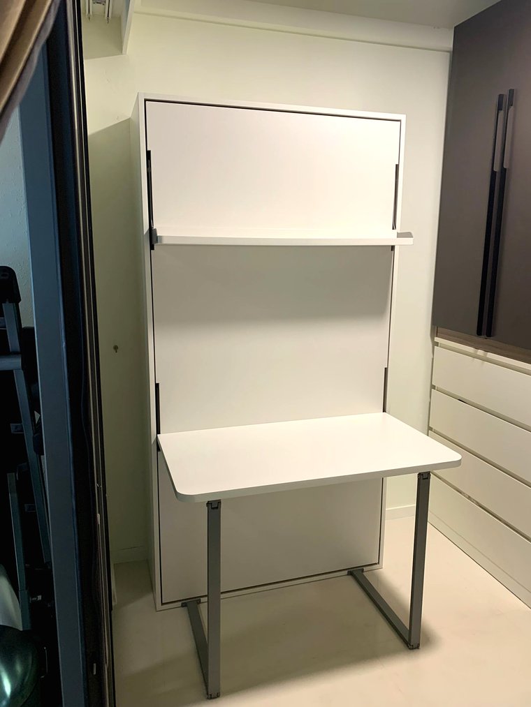 A Murphy bed with a desk folded down from the face of the bed cabinet.