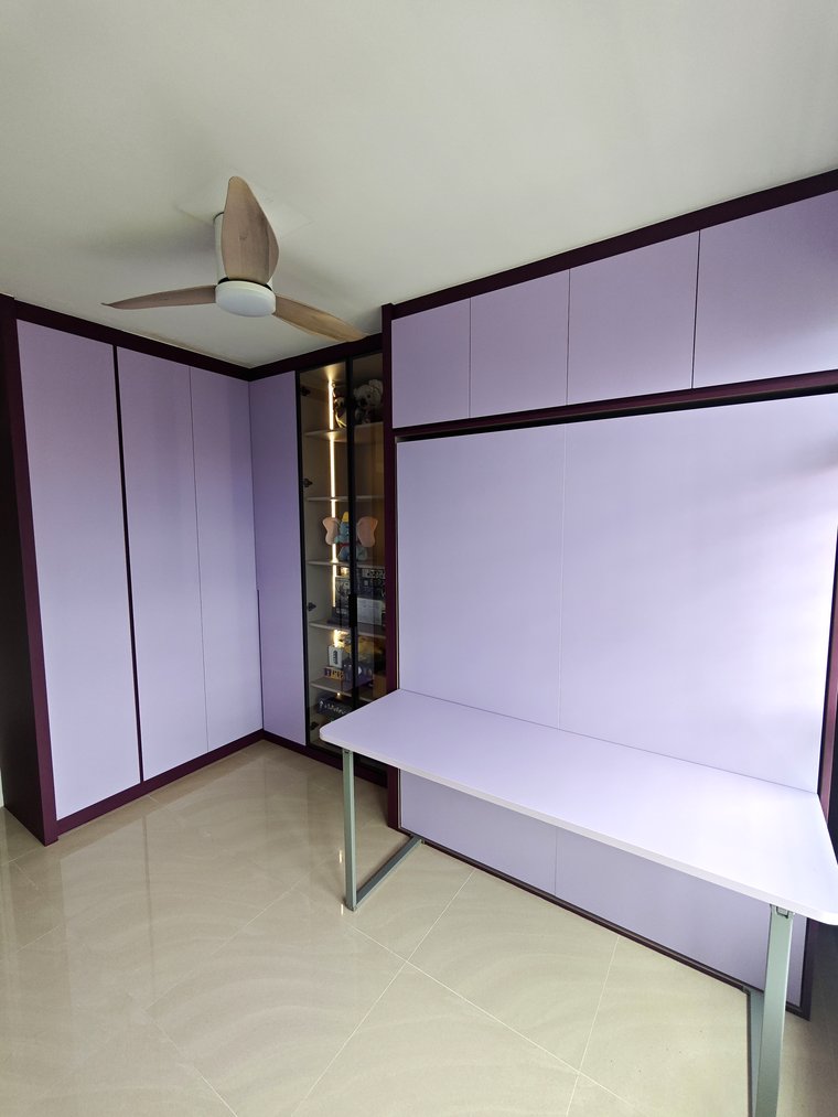 A completed study wall in lavender laminate with a matching desk in front of the closed Murphy bed.
