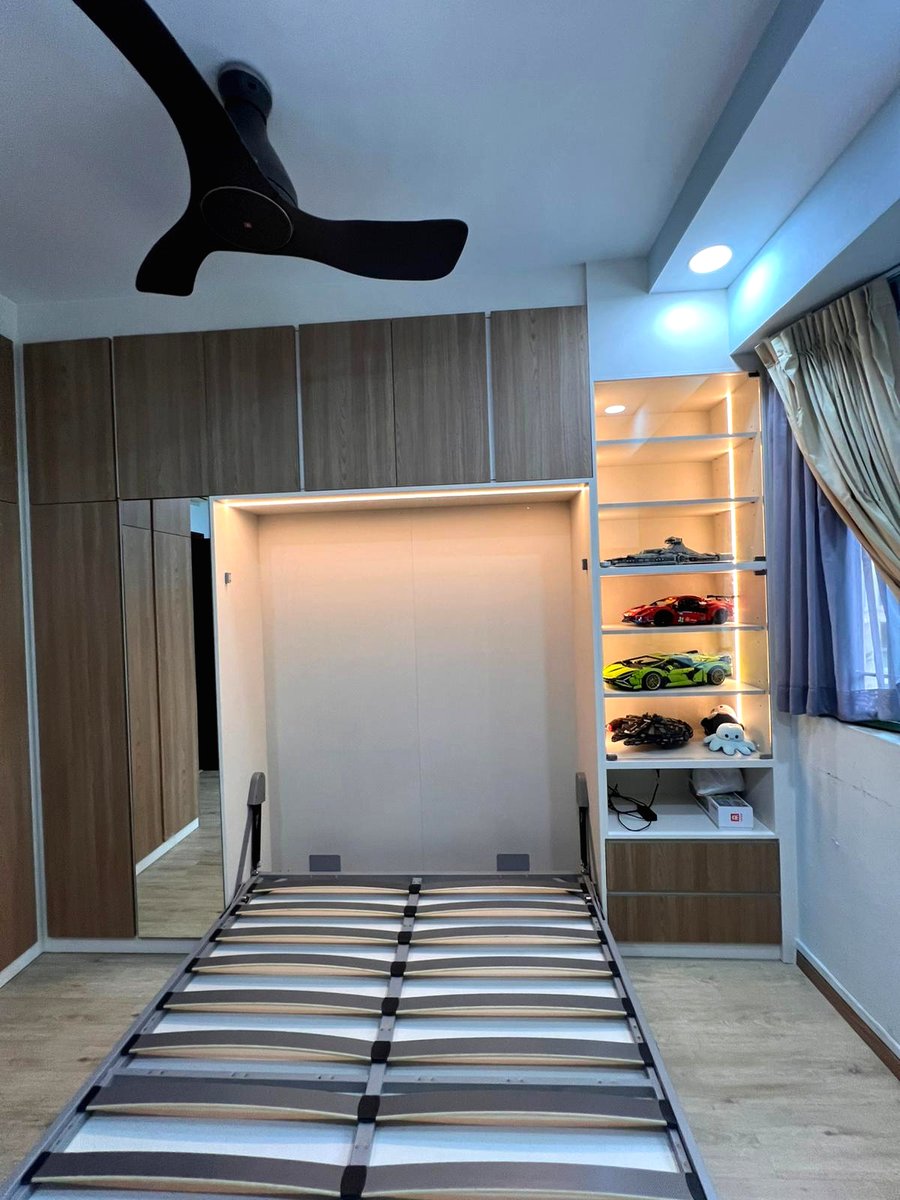 The same room with the Murphy bed folded down, the desk and shelving untouched around it.