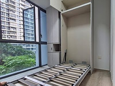 A wall bed folded down in a high-rise bedroom, its slatted frame open towards the window.