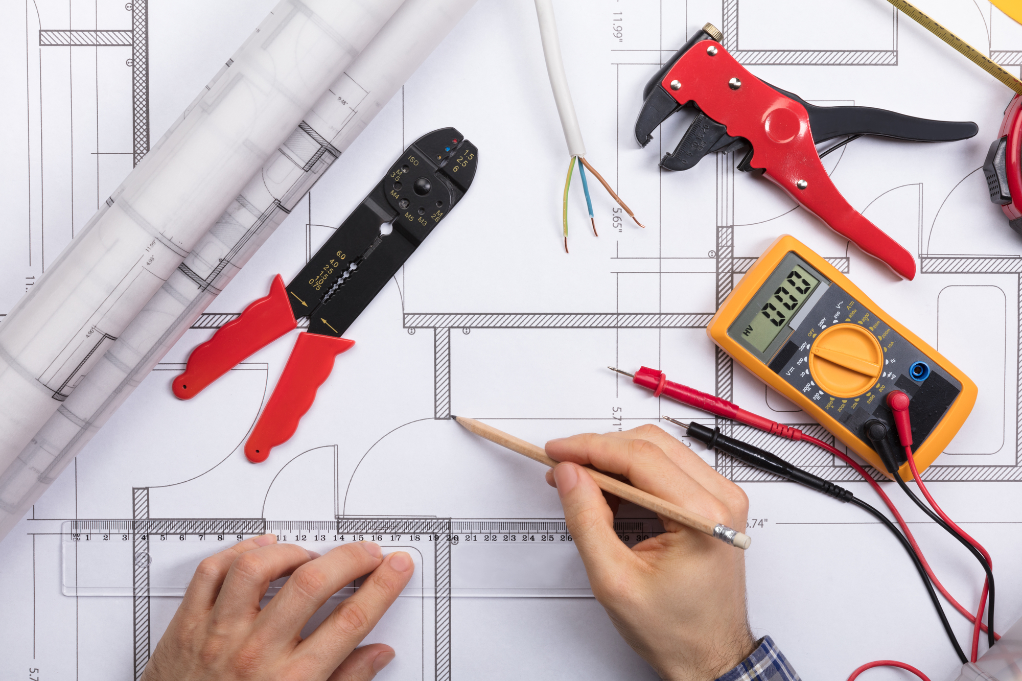 Elevated View Of An Architect Drawing Plan On Blueprint With Electrical Components